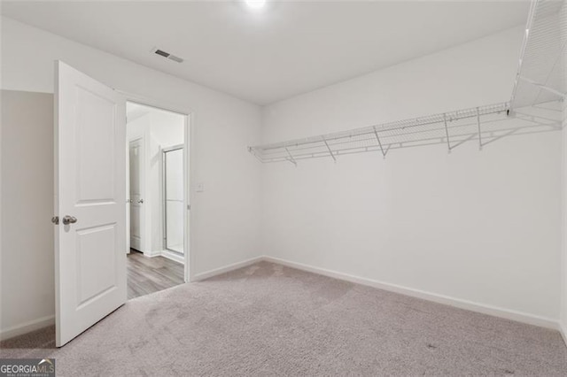 walk in closet with visible vents and carpet flooring