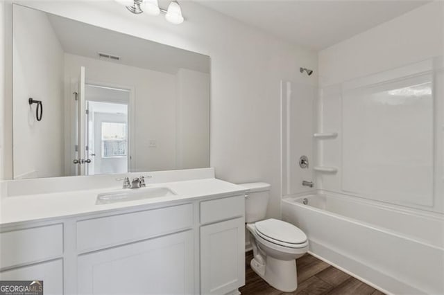 bathroom with bathing tub / shower combination, visible vents, toilet, vanity, and wood finished floors