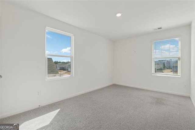 carpeted empty room with visible vents and baseboards