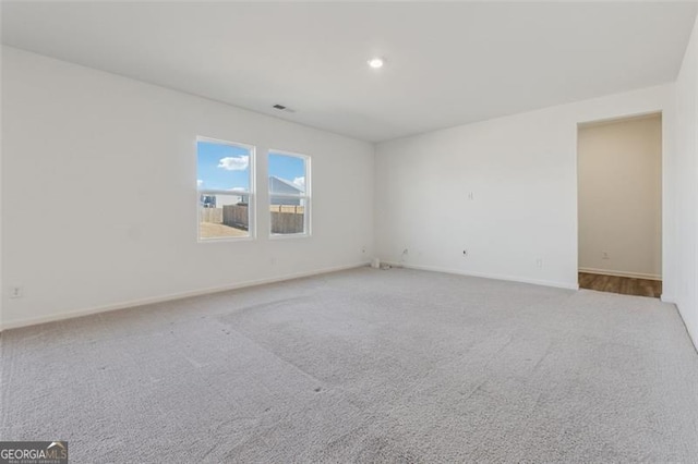 carpeted spare room featuring recessed lighting, visible vents, and baseboards