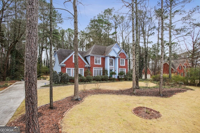 traditional-style home featuring brick siding and a front yard