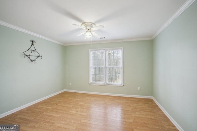 empty room with visible vents, light wood-style flooring, ornamental molding, a ceiling fan, and baseboards