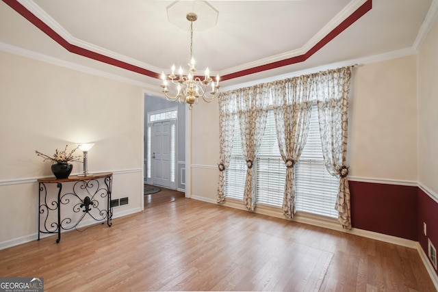 dining space with baseboards, a notable chandelier, visible vents, and wood finished floors