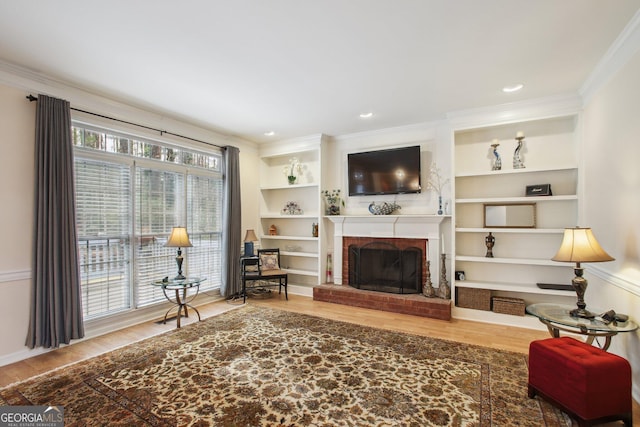 living room with built in features, a fireplace, recessed lighting, ornamental molding, and wood finished floors