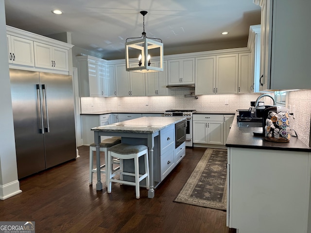 kitchen with dark wood-type flooring, a kitchen island, a sink, high quality appliances, and white cabinets