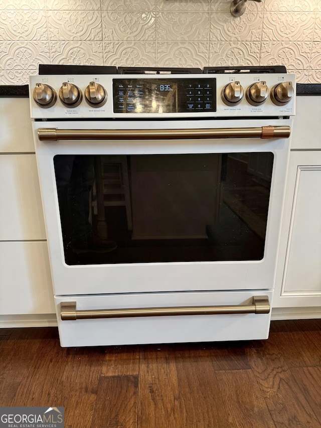 room details with white range with electric stovetop, wall oven, dark wood finished floors, and white cabinetry