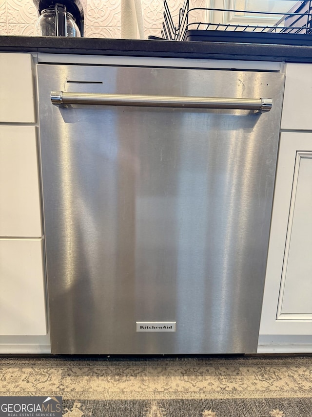 interior details with white cabinetry and stainless steel dishwasher