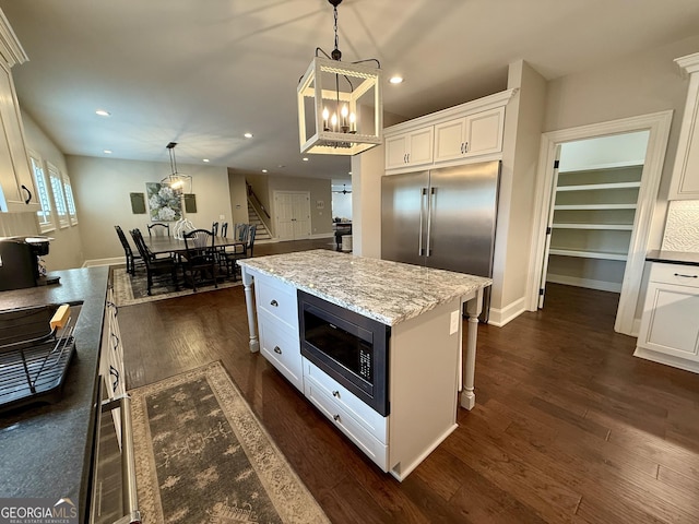 kitchen with recessed lighting, white cabinets, hanging light fixtures, built in microwave, and dark wood finished floors