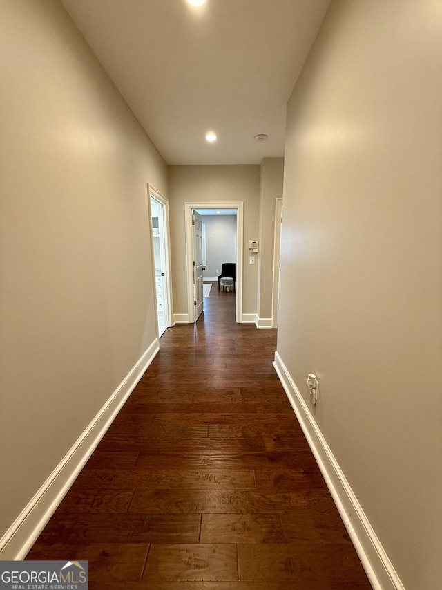 hall with baseboards, dark wood-type flooring, and recessed lighting