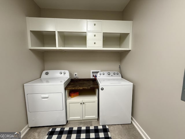 washroom featuring cabinet space, washing machine and dryer, and baseboards