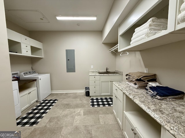 laundry area with washer hookup, cabinet space, a sink, electric panel, and baseboards