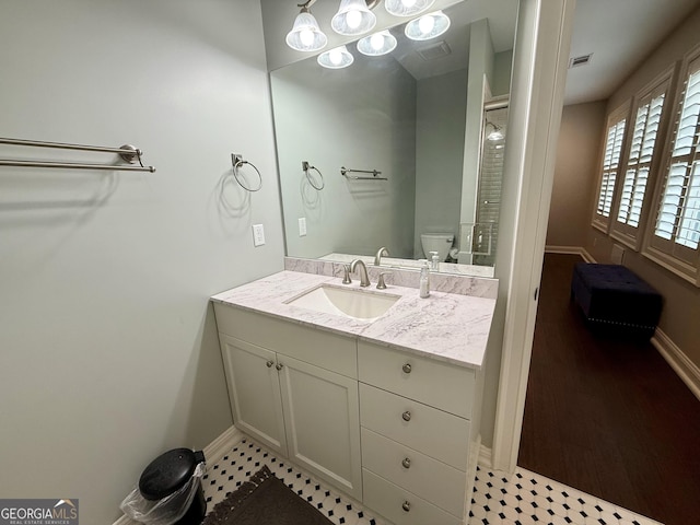 full bath with visible vents, toilet, vanity, and baseboards