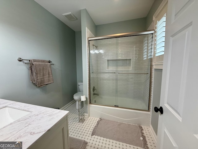 bathroom with baseboards, visible vents, bath / shower combo with glass door, toilet, and vanity