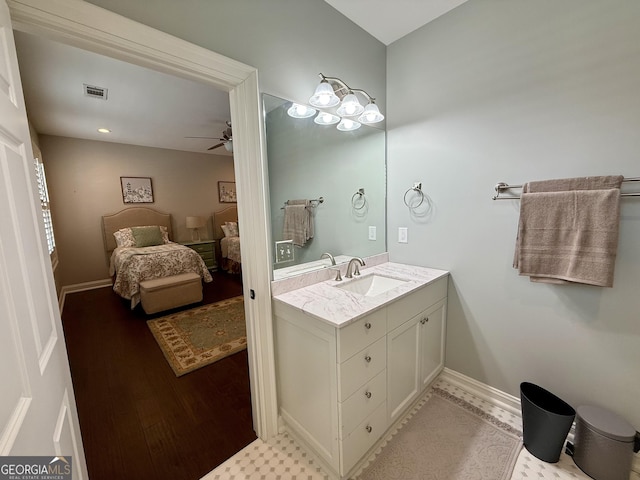 bathroom featuring baseboards, visible vents, a ceiling fan, wood finished floors, and vanity