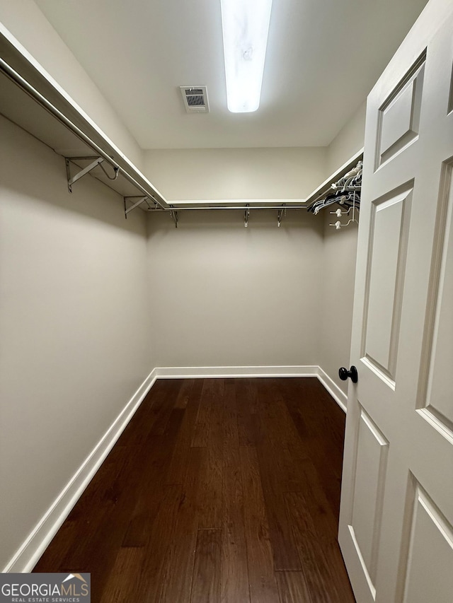 walk in closet with visible vents and dark wood finished floors