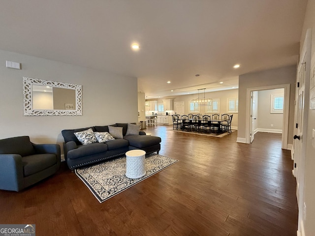 living room with dark wood-type flooring, recessed lighting, and baseboards