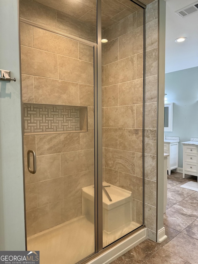 bathroom with a stall shower, baseboards, visible vents, and vanity