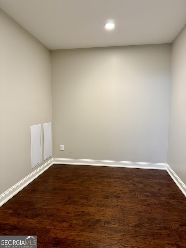 empty room with baseboards, dark wood-style flooring, and recessed lighting