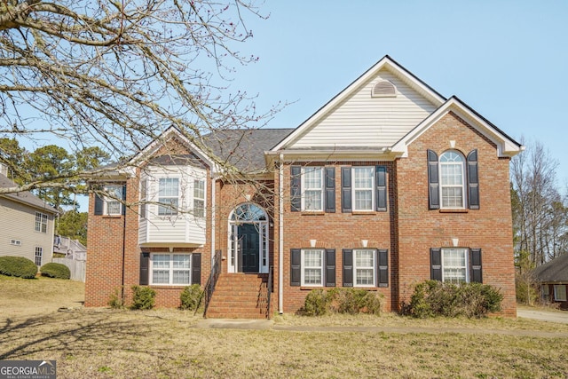 raised ranch with brick siding and a front yard