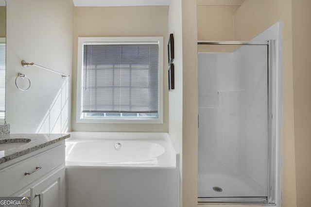 full bathroom with a stall shower, a garden tub, and vanity