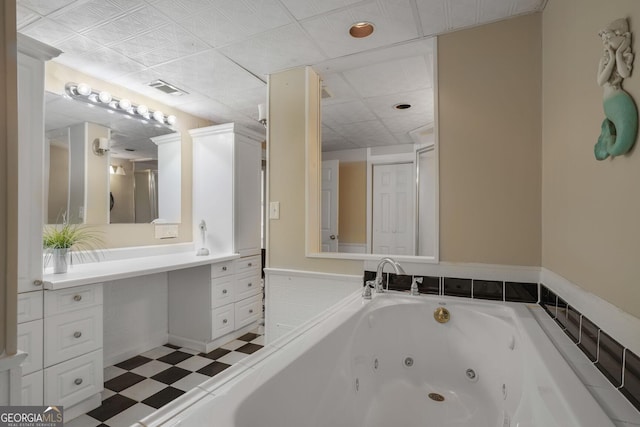 bathroom featuring a tub with jets, visible vents, and tile patterned floors