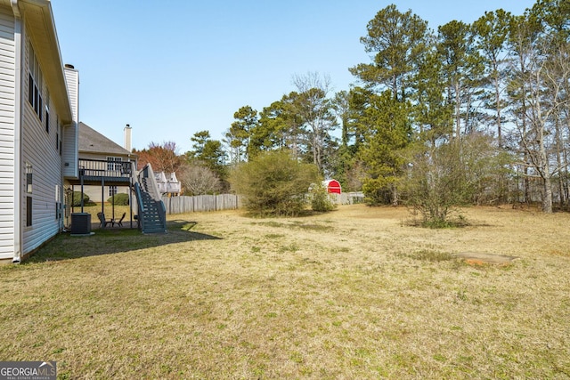 view of yard with central air condition unit, stairs, fence, and a wooden deck