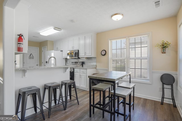 dining area featuring visible vents, dark wood finished floors, and baseboards