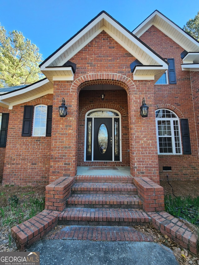 property entrance featuring brick siding