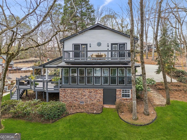 back of property featuring a sunroom, brick siding, crawl space, and a lawn