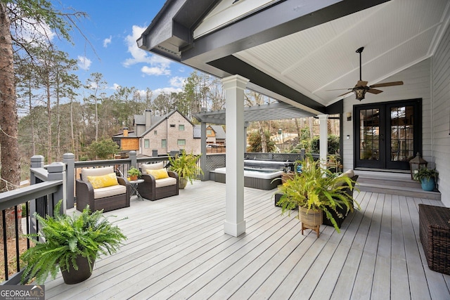 wooden terrace featuring french doors, hot tub deck surround, and ceiling fan