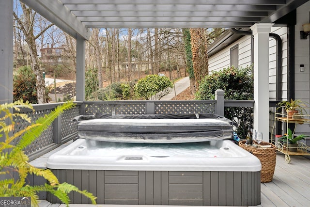 wooden deck with a hot tub and a pergola