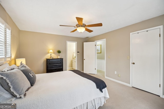 bedroom featuring carpet floors, a ceiling fan, baseboards, and ensuite bathroom