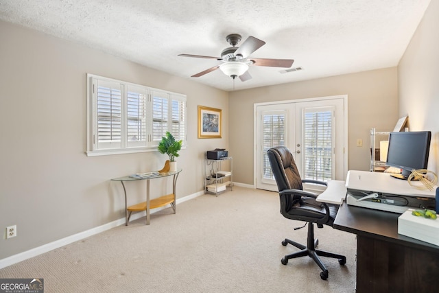 carpeted office space featuring french doors, a ceiling fan, visible vents, and baseboards