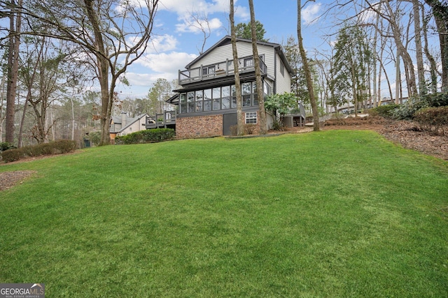 back of house featuring a balcony and a yard