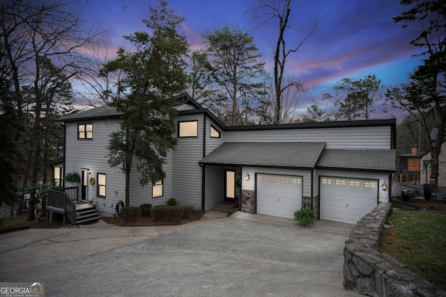 view of front of property featuring stone siding, concrete driveway, a shingled roof, and an attached garage