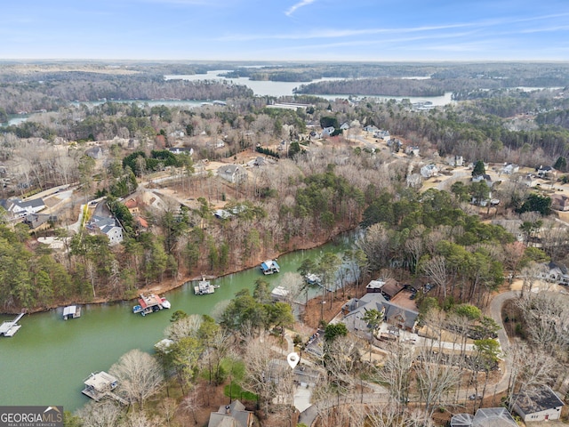 birds eye view of property with a water view and a view of trees