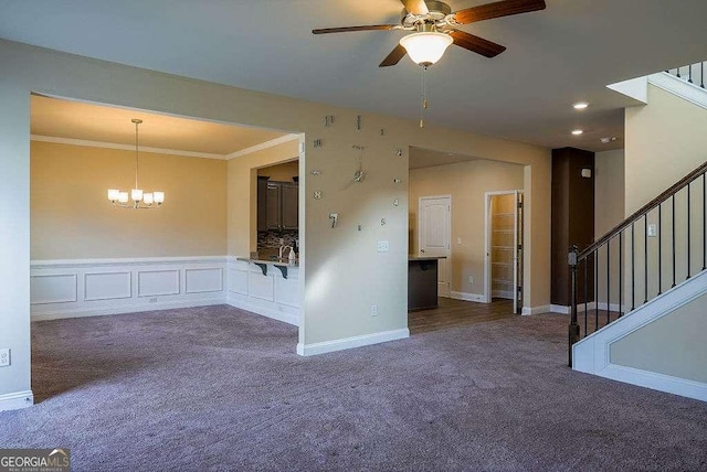unfurnished room with stairs, ornamental molding, ceiling fan with notable chandelier, and carpet flooring