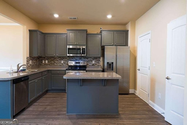 kitchen with stainless steel appliances, visible vents, backsplash, gray cabinetry, and a sink
