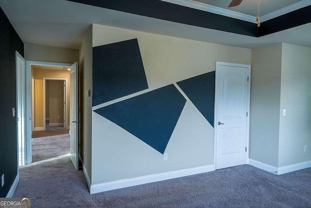 spare room featuring ornamental molding, carpet, ceiling fan, and baseboards