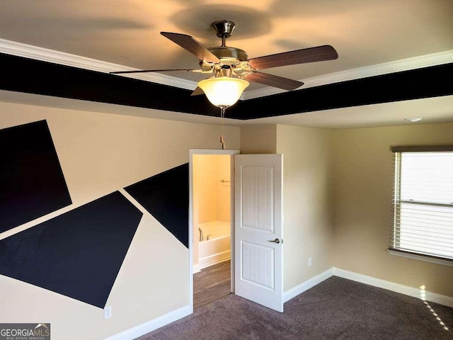 spare room featuring crown molding, carpet floors, a ceiling fan, and baseboards