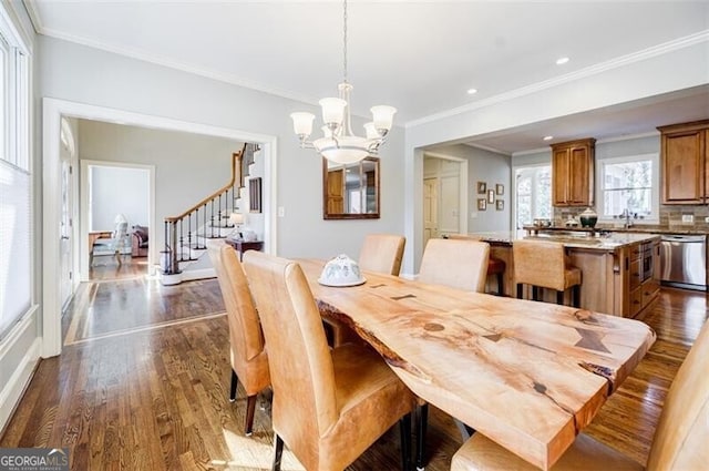 dining area with dark wood-type flooring, a chandelier, stairs, and ornamental molding