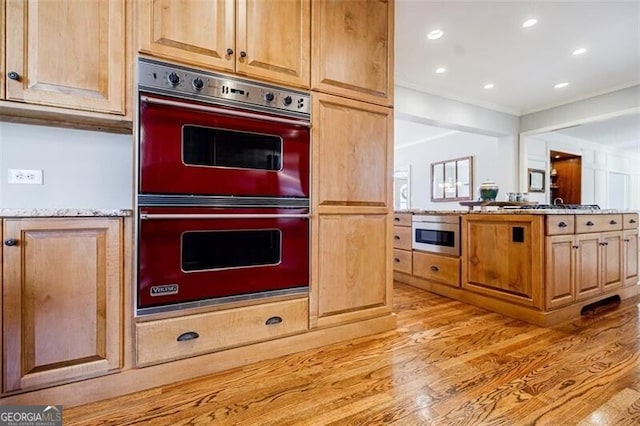 kitchen with light stone counters, double wall oven, light wood-style flooring, recessed lighting, and crown molding