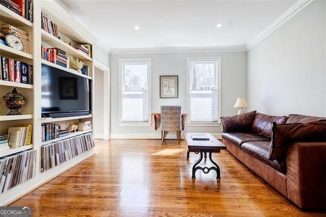 living area featuring built in features, wood finished floors, and ornamental molding