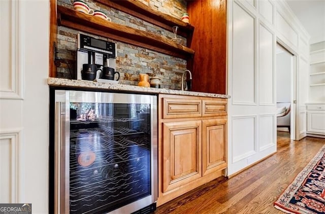 bar featuring indoor wet bar, wood finished floors, and beverage cooler