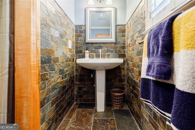 bathroom with a sink and stone finish flooring