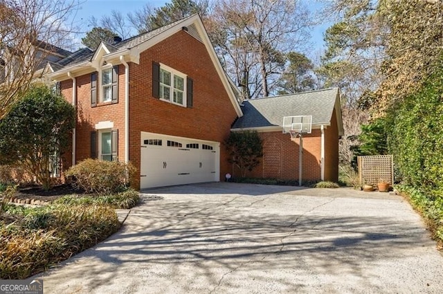 view of side of property featuring brick siding, concrete driveway, and a garage