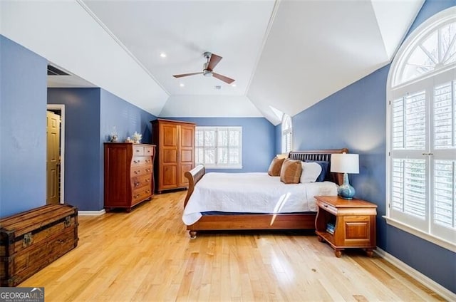 bedroom with multiple windows, lofted ceiling, baseboards, and light wood finished floors