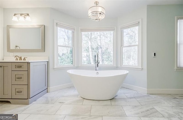 bathroom with a healthy amount of sunlight, marble finish floor, and baseboards