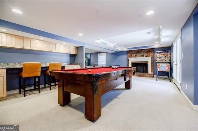 recreation room featuring recessed lighting, a raised ceiling, light carpet, and a fireplace