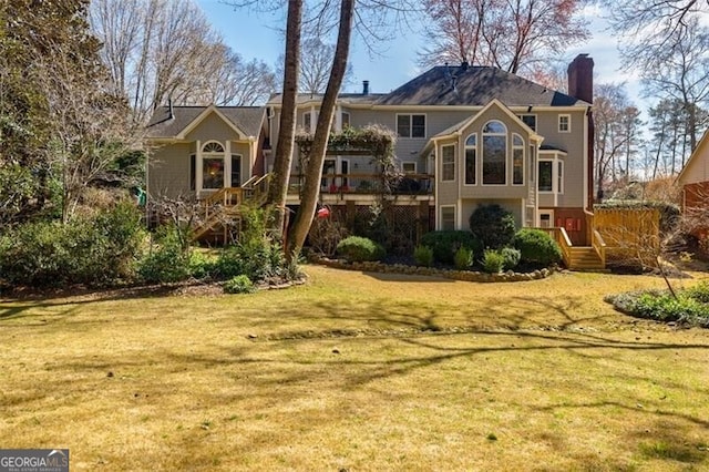 rear view of house featuring a yard and a chimney